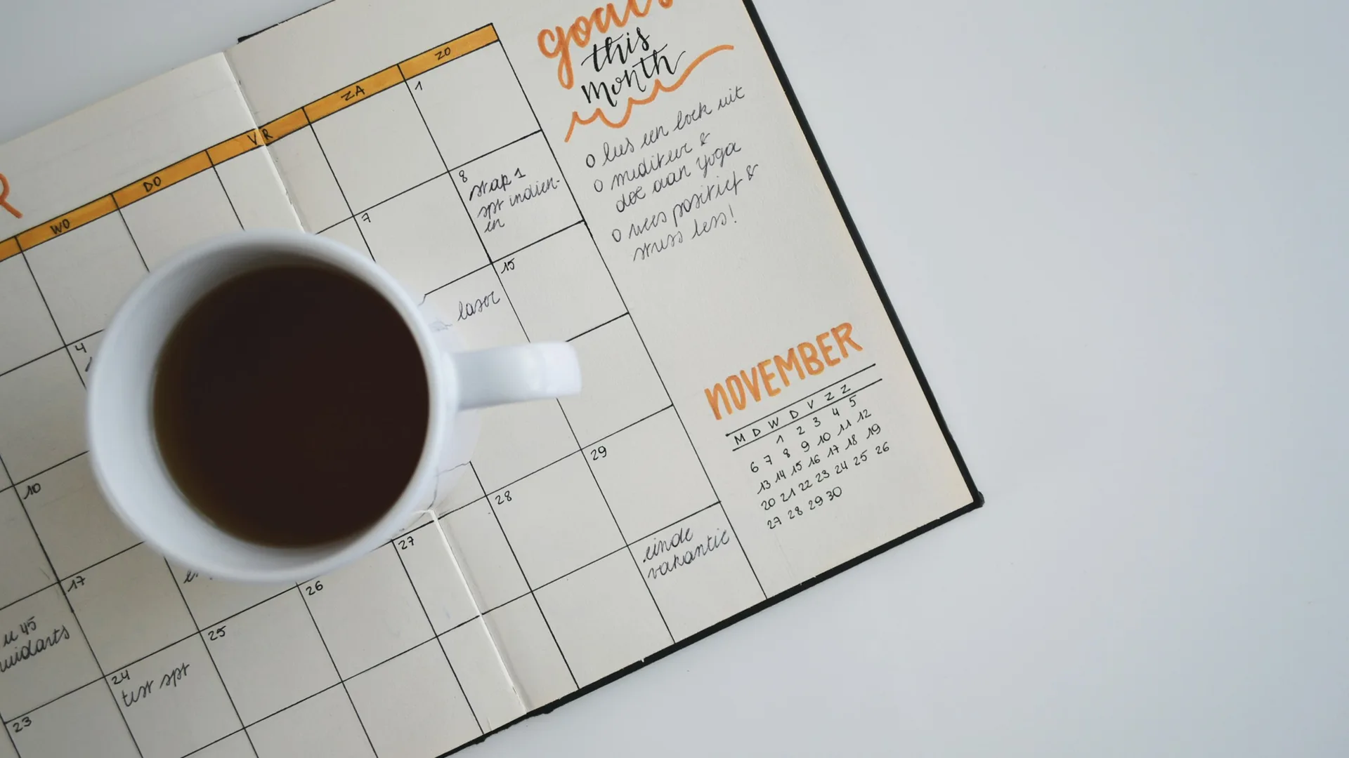 Open planner showing a November calendar, a coffee mug, and handwritten monthly goals