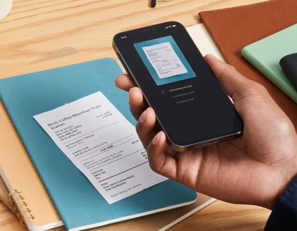 Hand scanning a coffee receipt with TapBooks on a phone